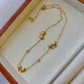 Elegante goldfarbene Halskette mit zarten Schleifen-Anhängern und klaren Kristallen - Dreifache Schleife Strass Kette Halskette / Gold