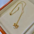 Elegant gold bow necklace featuring a clear heart crystal pendant in a cream jewelry box - Bow Rhinestone Heart Necklace / Gold