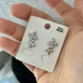 Glitzernde Blumenstecker mit Zirkonia-Besatz und Silbernadel auf einer Displaykarte - Ohrstecker / Silber