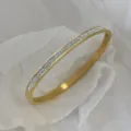 Elegante bracciale in acciaio al titanio placcato oro con tre file di pietre di zirconi - Modello con strass pavé a doppia fila / Oro