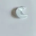 Gros plan d'un pendentif demi-lune en pierre œil-de-chat blanche effet chatoyant - Pendentif Lune Œil de Chat Synthétique (Pendentif Seul) / Blanc