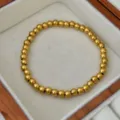 Elegantes, 18K vergoldetes Titanstahl-Perlenarmband präsentiert in einer edlen Holzkiste - Goldenes Perlen Elastisches Armband / 5mm