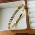 Elegante gouden titanium stalen armband met zirkonia inleg in een houten juwelendoosje - Lijnstijl / 4mm / Goud