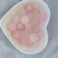 Gros plan détaillé de perles rondes en cristal rose dans un bol cœur, surface lisse accessoire. - Sans Trou / Quartz rose