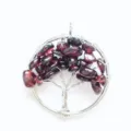 Close-up view of handmade wire-wrapped crystal tree of life pendant detail craftsmanship. - Garnet