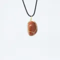 Collana con pendente in cristallo di pietra del sole avvolto in filo con cordino nero - Pietra del Sole Dorata Sintetica