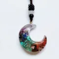 Detail shot of a resin crescent moon pendant filled with colorful crystal chips and copper wire. - Moons with Cord