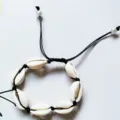 Detail du bracelet tisse de coquillages naturels boheme avec cordon cire noir et perle elegante. - Coquillages blancs à lignes noires