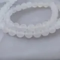 Close-up detail of smooth natural white agate round beads for DIY jewelry making and crafting. - 4mm / 7A White Agate