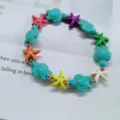 Close-up of beach-style beaded bracelet with turquoise turtles and colorful starfish - Starfish + Turtle