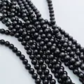 Gros plan détaillé de perles rondes en agate noire brillante et obsidienne pour bijoux DIY. - 4mm / Imitation agate noire (surface en verre lisse)