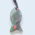 Gros plan détaillé du pendentif poisson en cristal avec inclusions minérales uniques. - Héliotrope africain