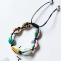 Boho natural cowrie shell braided bracelet detail featuring colorful painted shells and black cord. - Black Wire Colored Shells (Random Pattern)