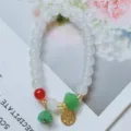 Bracelet de perles de style chinois avec perles blanches, breloques et pendentif doré. - Pendentif plaque de bonheur
