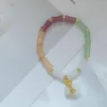 Bracelet en perles de bambou en jade colore avec des intercalaires dores et pendentif chic - Nœud de bambou et sac porte-bonheur