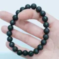 Vue détaillée du bracelet en perles de pierre de lave noire, design poreux naturel unisexe. - 6mm / Pierre de lave