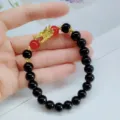 Bracelet de perles noires style chinois avec tête de dragon dorée et perles rouges femmes. - Noir