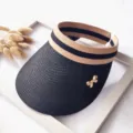 Detalle sombrero visera de sol de paja, banda de rayas negro beige con bonito lazo dorado. - Talla única / Negro