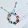 Handcrafted braided blue cord bracelet with colorful painted cowrie shells and pearl charms. - Blue Wire Colored Shells (Random Pattern)