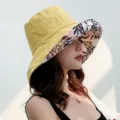 Detailed view of women's reversible bucket hat, featuring a wide floral brim and solid yellow side. - Adjustable / Yellow