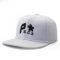 Detailed view of white flat brim snapback baseball cap featuring stylish black front embroidery. - Adjustable / White