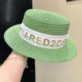 Detailed view of green flat-top straw hat with white lettered ribbon for beach vacation. - Adjustable / Green
