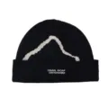 Detailed macro view of black winter knit beanie with white snow mountain silhouette. - One Size / Black