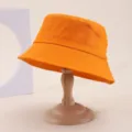 Close-up detail of the classic orange cotton bucket hat showcasing fabric texture and brim. - One Size / Bright Orange