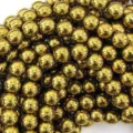 Macro view of 10mm gold-plated hematite round beads for Shamballa bracelets. - Gold