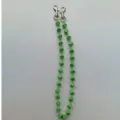 Groene dobbelsteen ketting detail close-up, acryl hiphop broekketting en modieus tas accessoire. - 2
