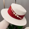 Detail shot of a chic summer straw hat featuring a red ribbon and elegant pearl bead chain. - Adjustable / Creamy White Hat Body Red Ribbon