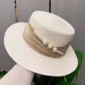 Close-up detail of summer flat top straw hat featuring pearl chain and ribbon decor. - Adjustable / Creamy White Hat Body Champagne Ribbon