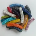Close up detail of colorful rhinestone paved polymer clay curved tube DIY jewelry beads. - Multicolor