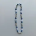 Detailed shot of a stylish beaded necklace featuring blue and silver pavé beads and white cross charms. - 10mm 5 Rows (56 Beads / 54cm) / Blue and Silver Cross Style (116)