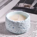 Handmade scented soy wax candle in a light blue textured cup for cozy bedroom decor. - Small Bluebell