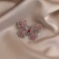 Close-up view of rhinestone butterfly brooch details with sparkling crystals on satin cloth. - 602# Pink