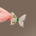 Elegant crystal butterfly brooch with green center stone, exquisite decorative accessory. - Gold