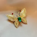 Close up of exquisite gold rhinestone butterfly brooch detail showing sparkling crystal stones. - Gold