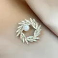 Elegant crystal rhinestone wreath brooch with faux pearl, silver tone variant for women. - No. 1033