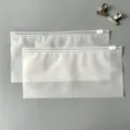 Primo piano dettaglio di buste con zip in PE smerigliato con cursore, custodia traslucida pratica. - Sacchetti con zip 20x10 cm