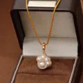 Elegante gouden kattenpoot ketting met parels en zirkonia in een bruine sieradendoos - Kattenpoot Stijl (Goud) / Goud