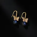 Elegante Schmetterlingsohrringe mit blauen Kristallanhängern auf schwarzem Grund. - Schmetterling-Anhänger / Dunkelblau