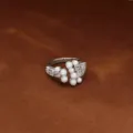 Elegante anillo ajustable plateado con perlas y circonitas brillantes sobre fondo marrón. - Apertura Ajustable (JZ1005-1) / Plateado