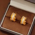 Elegantes pendientes en C bañados en oro con textura arrugada e incrustación de circón - Estilo de Circonia Plisada (EH16437) / Dorado