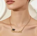 Close-up detail of the gold graduation necklace featuring letter pendant for stylish students. - Black & Gold Tone