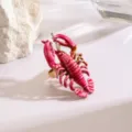 Primo piano di un anello aragosta smaltato rosa, lega dettagliata, accessorio di moda elegante. - Oro d'imitazione rosso rosa (X2663)