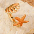 Primo piano dettagliato dell'anello aperto dorato con dettagli di conchiglia e stella marina. - Imitazione oro arancione (M1706)