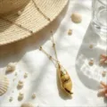 Close-up detail of ocean resort style conch shell pendant necklace on white fabric background. - Conch Bead Chain Necklace (Style 9)