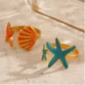Close-up detail of ocean resort style alloy starfish and seashell rings with vibrant enamel. - m1708 Imitation Gold