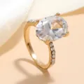 Gedetailleerde close-up van een vergulde ring met schitterende ovale kristal en stenen. - Wit KC-verguld 17# M204